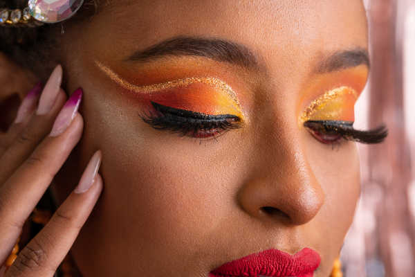 Foto de mulher negra maquiada para o carnaval ilustra artigo sobre cuidados oculares com make carnavalesca