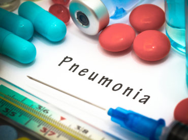 fundo branco, com escrito ‘pneumonia’ centralizado em preto; abaixo, uma agulha e um termômetro, ao redor, pílulas e ampolas; representam como a pneumonia pode afetar sua visão.